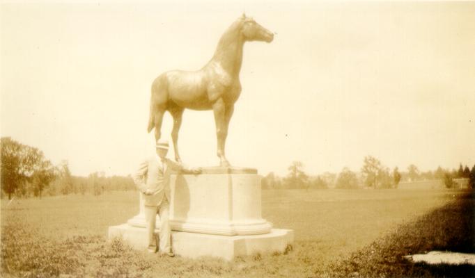 Man, possibly Samuel M. Wilson, standing in front of a statue of a horse