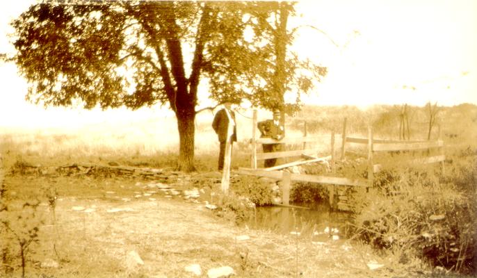 Two men on a small bridge over a creek (Duplicate of #60.)