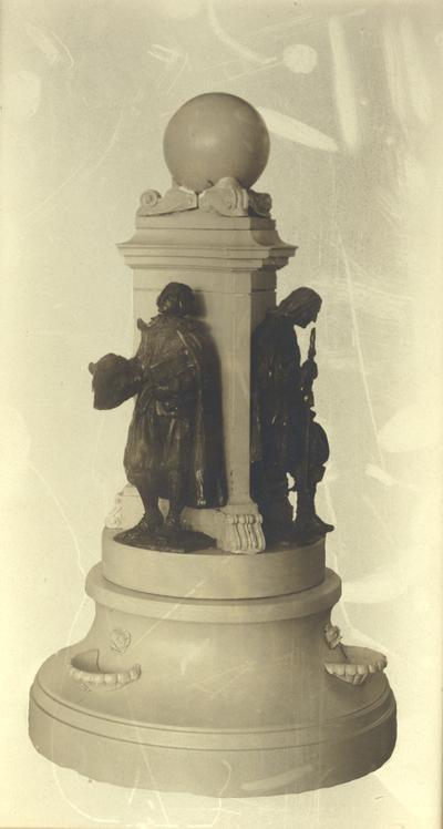 Two small soldier statues standing on a pedestal