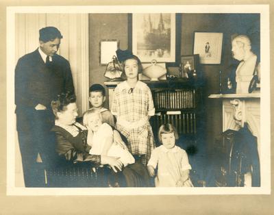 Family posed in living room, handwritten on back in ink 