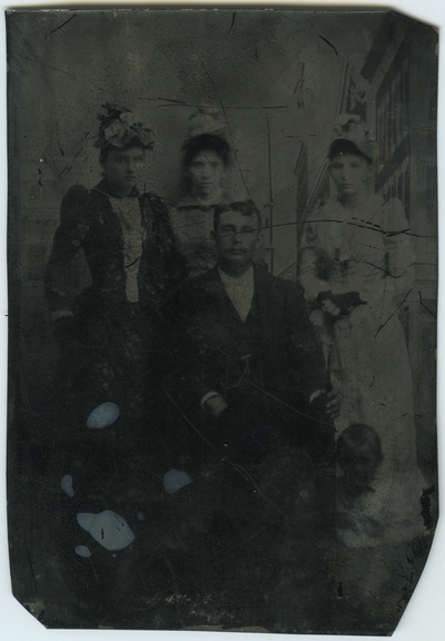 Unidentified male, three unknown females, and one unknown male child ; photo located on page 20 of album