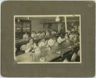 Domestic science class at Lincoln Grant High School in Covington, Kentucky picturing unidentified female students, principal William H. Fouse (1868-1944), and teacher Lillian Crutchfield ; written on back, 
