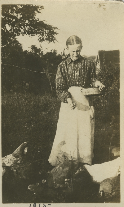 woman feeding chickens 1915