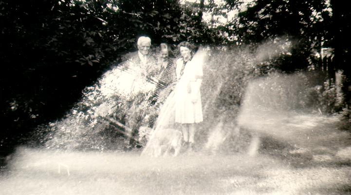 DeGroate, two women, and dog in yard (double exposure)