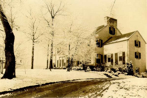 View of large, white house in wintry setting