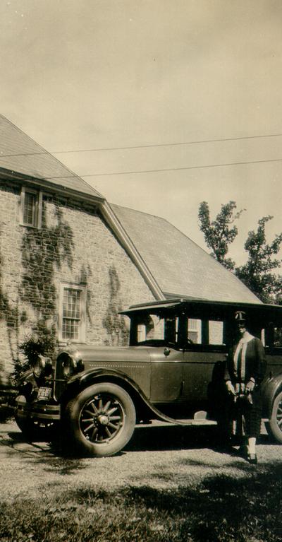 Mary Shelby Wilson in front of vintage automobile and brick building, Monticello