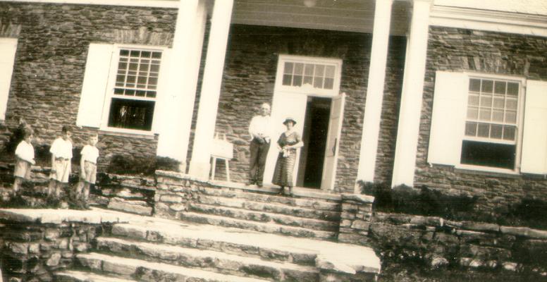 Mary Shelby Wilson and a man at the top of the steps to a building; three boys to the left