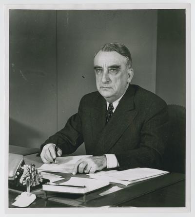 Vinson as Economic Stabilization Director, at desk with pen in hand