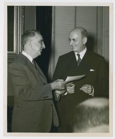 Secretary of the Treasury Vinson hands document to former Secretary of Treasury Henry Morgenthau
