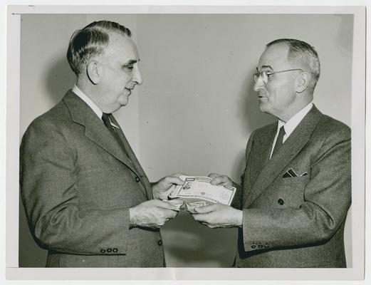 Secretary of the Treasury Vinson with President Harry S.Truman, buying first Victory Loan Bond
