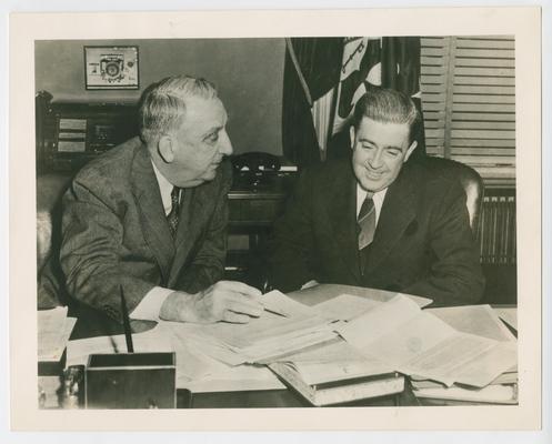 Secretary Vinson with his assistant, Paul L. Kelley, examining files