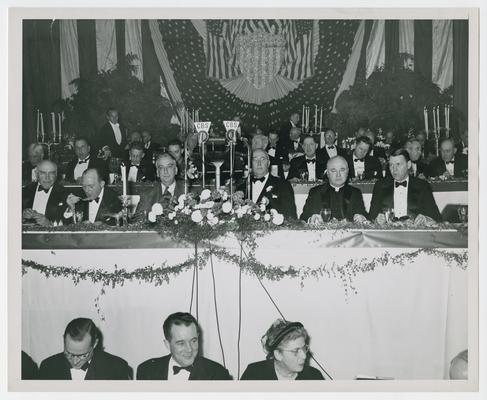 Secretary Vinson, left of microphones on front row of dais, at New York County War Bond Committee Dinner