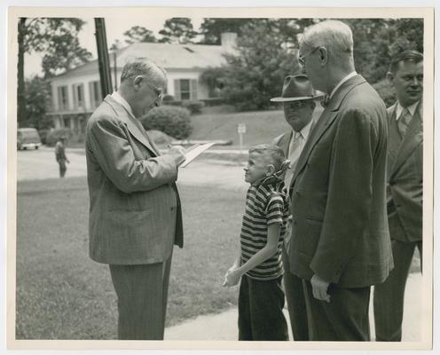 Chief Justice Vinson signs autograph for small boy