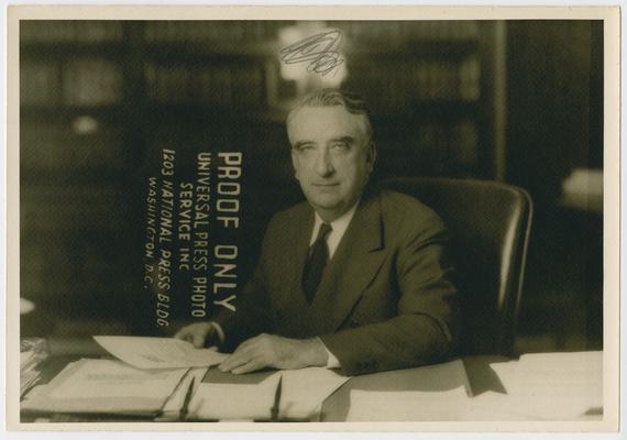 Chief Justice Vinson behind desk with papers