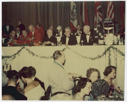 Chief Justice Vinson, front row of dais above crowd