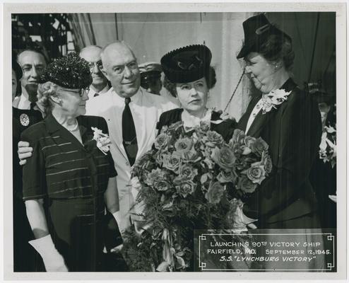 Page 8 of 38, Mrs. Vinson, roses in hand, with group of men and women