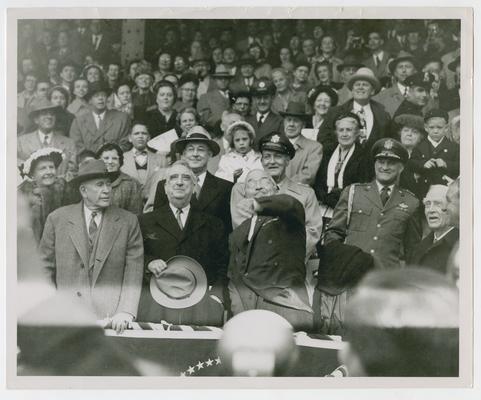 President Truman throws baseball at Griffith Stadium. Chief Justice Vinson stands left of the President in the President's Box