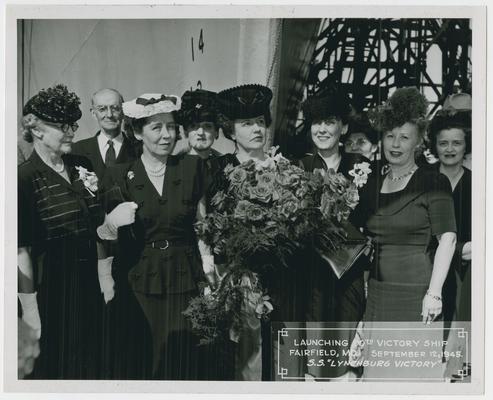 Page 10 of 38, Mrs. Vinson, roses in hand, with many women and one man