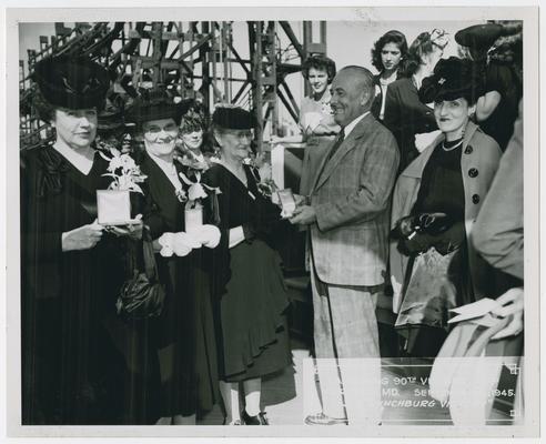 Page 24 of 38, second of two women with Mrs. Vinson as she receives plaque