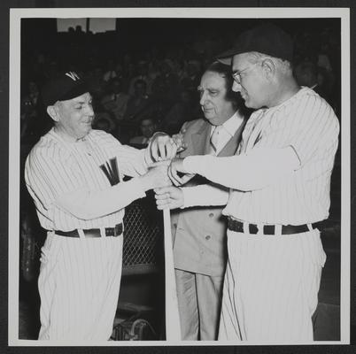 Chief Justice Vinson between opposing team players as they determine first team at bat, Griffith Stadium