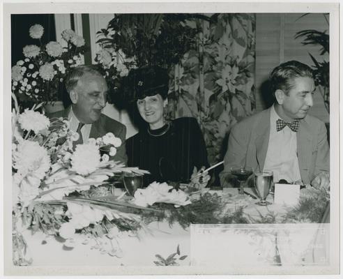 Page 33 of 38, Vinson with unidentified man and woman at dinner