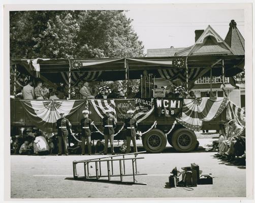 Page 9 of 13, parked wagon with bunting for special guests and speaker's podium