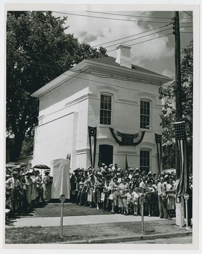 Page 12 of 13, crowd gathers at decorated building
