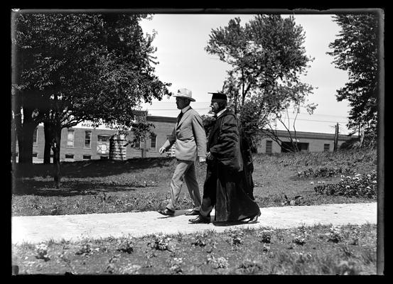 Commencement procession, Dr. Benjamin Ide Wheeler and man in civilian clothes, entrance stone posts in background
