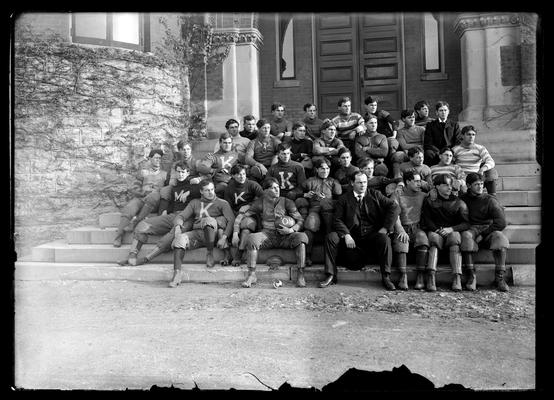 Football squad on steps of Health Building (old Chemistry Building), Coach Fred E. Schacht