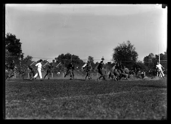 Football action near end of field, player four to right