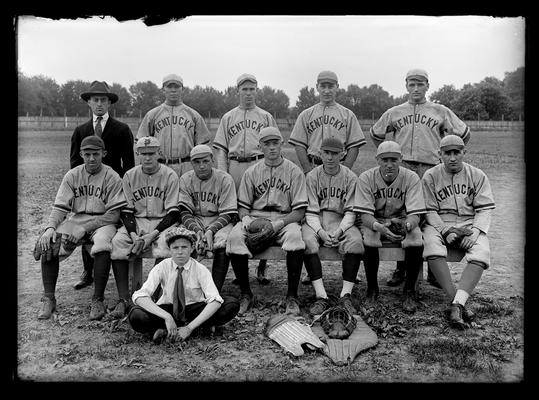 Players and coach, one player in civilian attire, catcher's gear on ground