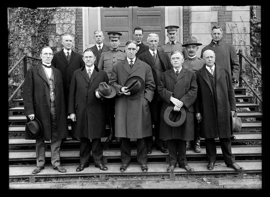 Thirteen men on steps of Administration Building (Main Building), Dr. McVey center front, D.H. Peak left of back row
