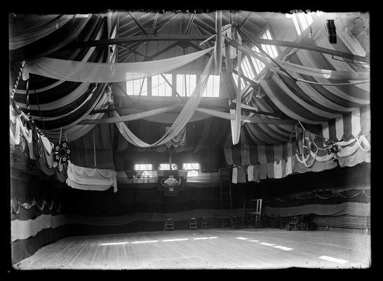 Interior of gymnasium in Barker Hall decorated with fraternity emblems