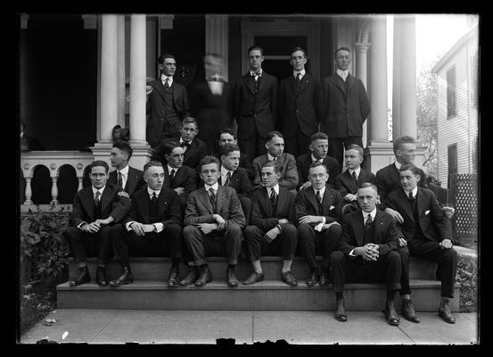 Fraternity group on steps of house with door to right