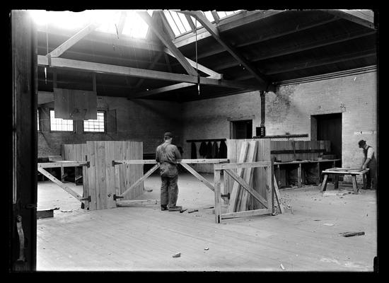 Carpenter shop set up in old school gym, two men