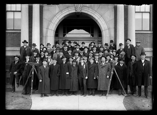Civil engineering group, possibly from highway engineering, in front of Penc Hall, transit on tripod, President H.S. Barker in derby against post to right of picture
