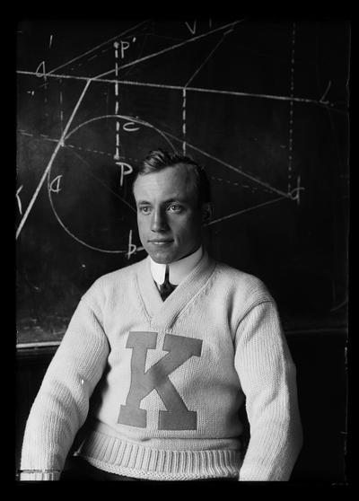 Jake Gaiser, 1912 BSME sweater with K, geometrical drawing in background