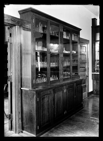 Experiment Station laboratory cabinet with four large glass doors and wooden doors below