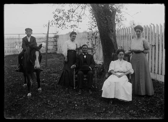 Group portrait, a child sitting on a horse