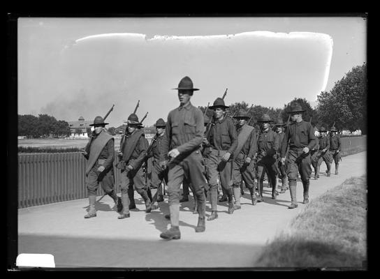 Soldiers, rifles on shoulder, wide walk, picket fence to left, Looking Forward, progress at end of sixth week, fair grounds