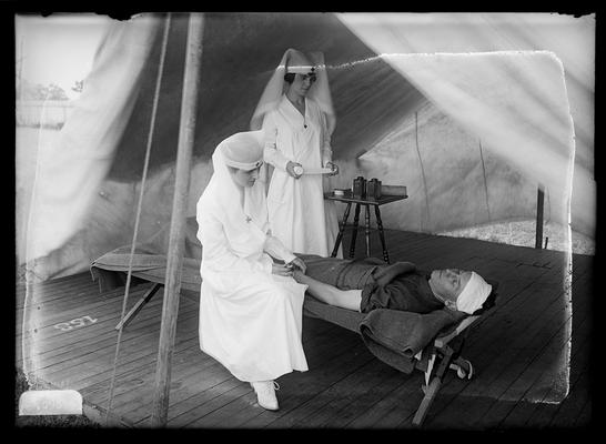 Two nurses with ill soldier in tent, notation Oh you nurse