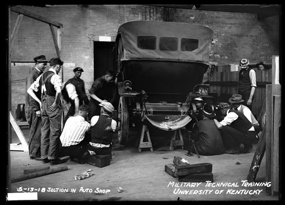 Men around car, notation section in auto shop