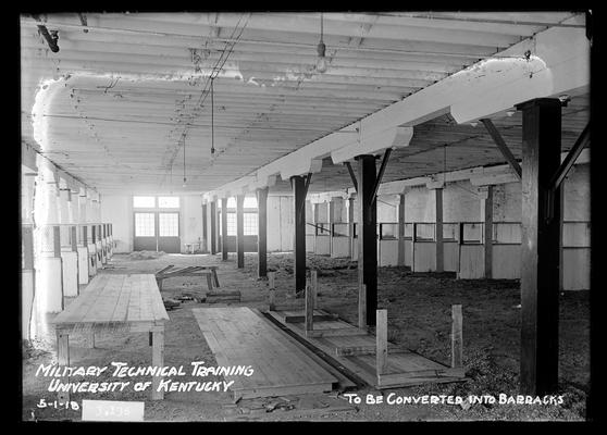 Large building, two double doors at end, partitions on each side, posts through center, notation to be converted into barracks