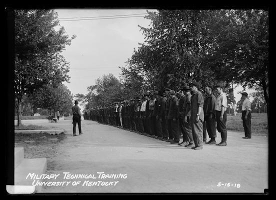 Men in work clothes lined up for review, notation A first week line