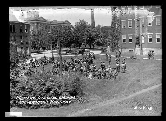 Relaxing on campus, some seated on ground, Administration Building (Main Building) to left, Miller Hall in right background