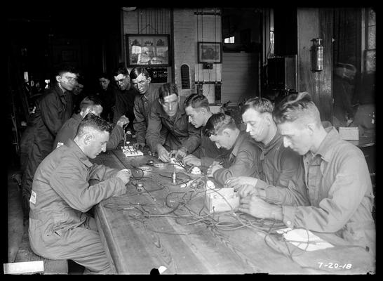 Electrical exercises in wiring, men along sides of long table