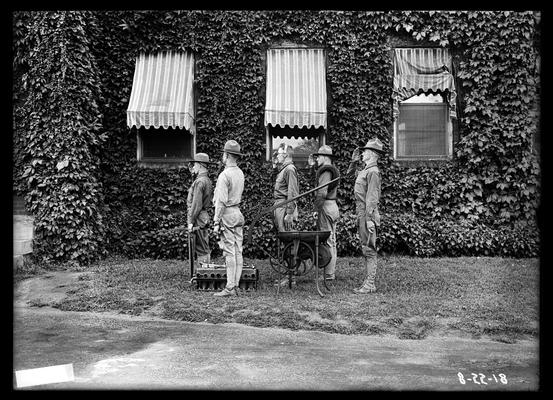 Five men in front of ivy covered building, possibly Mechanical Hall, radio equipment