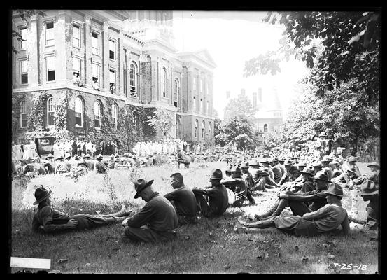 Men at ease listening to Navy band, note women in windows with feet outside, Administration Building (Main Building)