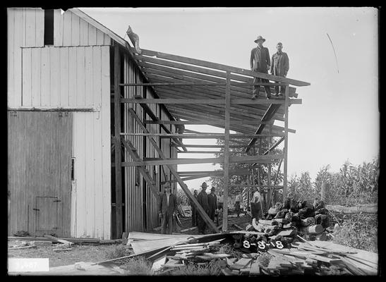 Carpenters at work on extension to a barn