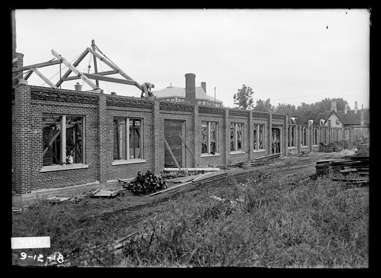 Brick building under construction, addtion to Mechanical Hall, Miller Hall roof in center background, Commandant's house to right